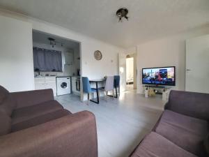 a living room with a couch and a table with chairs at 2 Bedroom Flat near Heathrow airport in Yiewsley