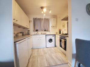 una cucina con lavatrice e asciugatrice di 2 Bedroom Flat near Heathrow airport a Yiewsley