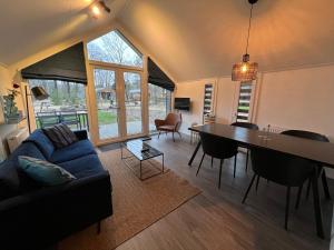 ein Wohnzimmer mit einem blauen Sofa und einem Tisch in der Unterkunft Holiday Home Maridu Forest in Arnhem