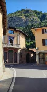a building on a street with a mountain in the background at Corte del Cedro in Provaglio d'Iseo