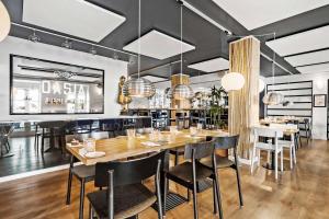 a dining room with a large wooden table and chairs at Best Western ToRVEhallerne in Vejle