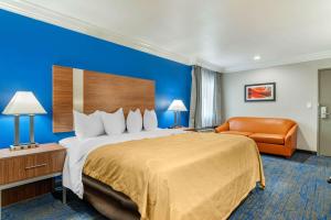 a hotel room with a large bed and a chair at Quality Inn & Suites Vacaville in Vacaville