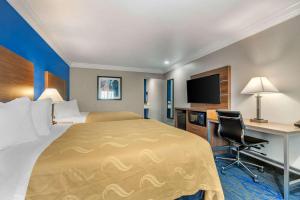 a hotel room with a bed and a desk at Quality Inn & Suites Vacaville in Vacaville