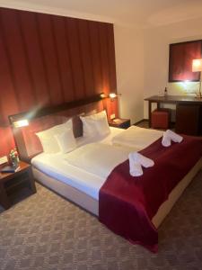 Hotel Villa Sophia في فارندورف: غرفة فندق بسرير كبير عليها مناشف