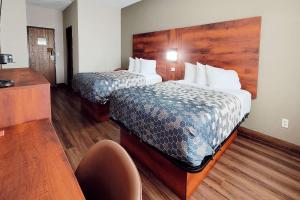 una habitación de hotel con 2 camas y una silla en Econo Lodge, en Fargo