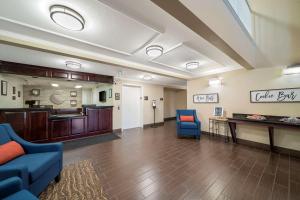 a large waiting room with blue chairs and a table at Comfort Suites Red Bluff near I-5 in Red Bluff