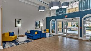 a living room with blue and yellow furniture in a building at Comfort Suites Salisbury I-85 in Salisbury