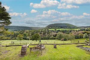 a bench in a field with a hill in the background at 2 x Double Bed Glamping Wagon in Dalby Forest in Scarborough