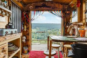 a kitchen with a table and a large window at Glamping Wagon - 1 x Double Bed 2 x Single Bed in Scarborough