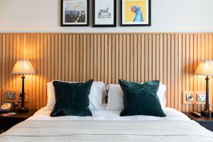 a bedroom with a bed with two lamps and two pillows at The Park Hotel in Teddington
