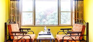 Pokój z krzesłami, stołem i oknem w obiekcie Mountview Resort w mieście Lonavla
