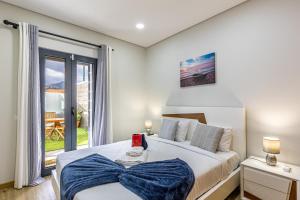 una camera da letto con un letto e una grande finestra di Casa da Praia, 2min de la PLAGE, hyper centre a Machico