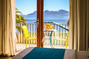 a room with a balcony with a view of the ocean at Apartamentos Torre Playa in Port de Pollensa
