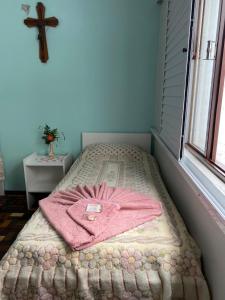 ein Bett mit einem rosa Bademantel auf dem Zimmer in der Unterkunft Pousada Irmãs Franciscanas in Lages