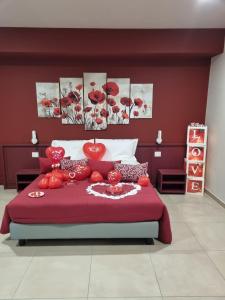 a bedroom with a large red bed with tomatoes on it at Rosy's Rooms in Patrica