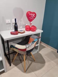 une table avec une chaise, un ballon et des verres à vin dans l'établissement Rosy's Rooms, à Patrica