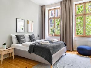 een witte slaapkamer met een bed en 2 ramen bij Schoenhouse City Street in Berlijn
