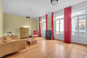 uma sala de estar com um sofá e cortinas vermelhas em Rare pearl very quiet and bright in Toulouse em Toulouse