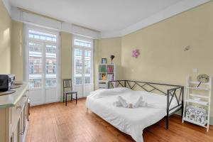 um quarto com uma cama e uma cozinha com janelas em Rare pearl very quiet and bright in Toulouse em Toulouse