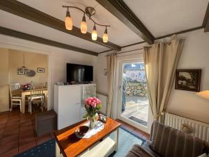 uma sala de estar com uma mesa com flores em Moby Dick im Haus Käpt'n Andresen em Westerland