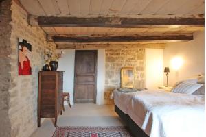 a bedroom with a bed and a stone wall at Chateau d 'Impasse in Laferté-sur-Amance