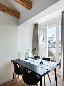 a dining room with a black table and chairs at Schoenhouse City Street in Berlin