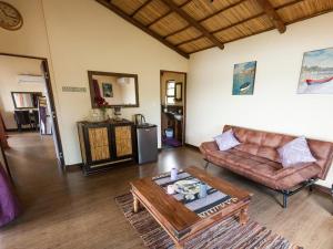 uma sala de estar com um sofá e uma mesa em Nghunghwa Lodge em Vila Praia do Bilene