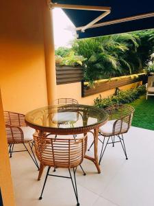eine Terrasse mit einem Glastisch und Stühlen auf einer Terrasse in der Unterkunft Meloneras Garden Suite in Meloneras