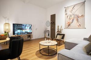 ein Wohnzimmer mit einem Sofa und einem Tisch in der Unterkunft Park Avenue Apartments - Dom mit Stil - Küche - Parkplatz - WLAN - 65 Zoll TV - NETFLIX in Köln