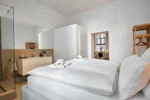 Park Avenue Apartments - Dom mit Stil - Küche - Parkplatz - WLAN - 65 Zoll TV - NETFLIX في كولونيا: غرفة نوم بيضاء مع سرير كبير ومرآة