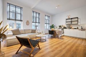 a living room with a couch and a table at Park Avenue Apartments - Dom mit Stil - Küche - Parkplatz - WLAN - 65 Zoll TV - NETFLIX in Cologne