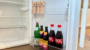 an open refrigerator filled with bottles of cocacola at Gemütliches Apartment in Gelsenkirchen