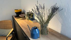 a wooden table with a vase on a table with a clock and a v at Gemütliches Apartment in Gelsenkirchen