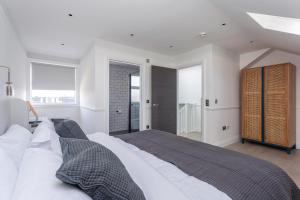 a bedroom with a large bed with white sheets at The Stanley Maisonette in Teddington