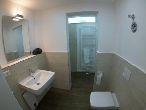 ヴィスマールにあるOhle26 - Loft Ferienwohnungのバスルーム(洗面台、トイレ、鏡付)