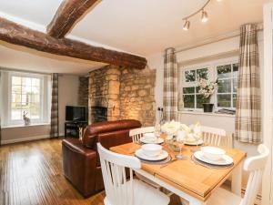 a dining room with a table and a couch at Barton Cottage in Cheltenham