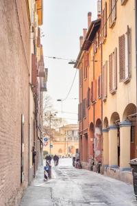 an alley with buildings and a horse walking down a street at Borgo dalle Tovaglie in Bologna