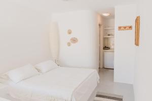 um quarto branco com uma cama branca e uma cozinha em Kontseta em Mérichas