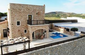 a stone house with a patio and a swimming pool at Deluxe Villa LaCasa 2 with Private Pool in Roumelí