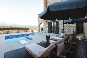 a pool with two lounge chairs and an umbrella at Deluxe Villa LaCasa 2 with Private Pool in Roumelí