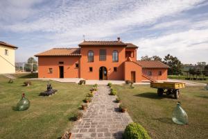 una casa naranja con un camino de ladrillo que conduce a ella en Incanto Toscano, en Larciano