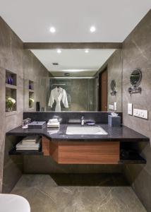 a bathroom with a sink and a large mirror at Vivanta Mangalore Oldport Road - Formerly Known as Taj Manjarun in Mangalore