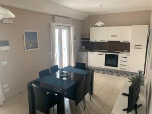 a kitchen and dining room with blue tables and chairs at Za Catarí in Campora San Giovanni