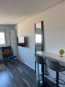 カールスルーエにあるSkyline Apartment Belle Vueの鏡、テーブル、椅子が備わる客室です。