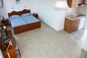 a room with a bed and a table and a kitchen at Naxos Edem Studios & Apartments in Naxos Chora