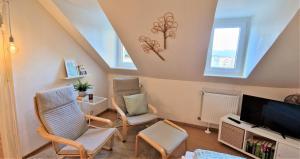 ein Wohnzimmer mit 2 Stühlen und einem Flachbild-TV in der Unterkunft liebenswertes Apartment 10 Minuten zur Altstadt in Koblenz