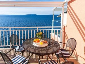 una mesa y sillas en un balcón con vistas al océano en Lemon tree en Podaca
