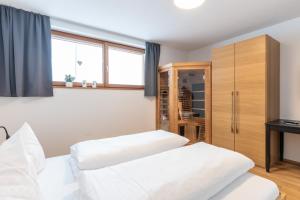 een slaapkamer met 2 bedden en een kast bij Faschina Apartment - Top 1 in Fontanella