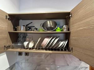 a shelf with plates and utensils in a kitchen at Ano Poli Studios 1 in Thessaloniki