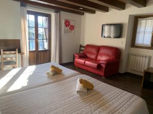 sypialnia z łóżkiem i czerwoną kanapą w obiekcie Casa Taconera w mieście Ansó